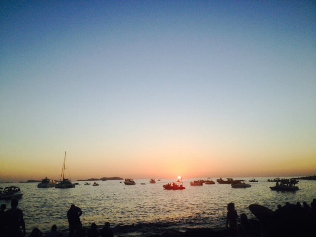 Verschwindende Sonne an der Bucht Cala des Moro mit Booten auf dem Meer