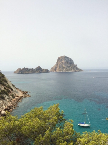 Blick auf Es Vedrá mit Segelboot im türkisblauen Meer