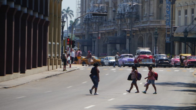 Kubaner auf der Straße und Oldtimer im Hintergrund