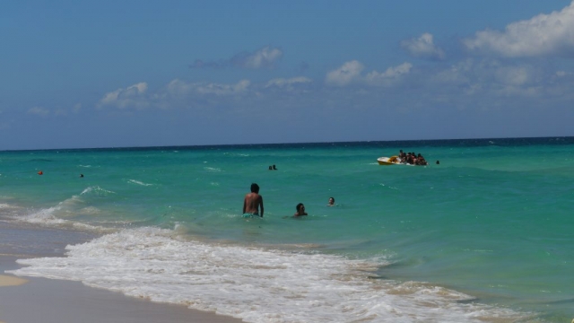 Menschen baden im Meer und Gruppe auf einem Tretboot – Santa María del Mar, Playas de Este