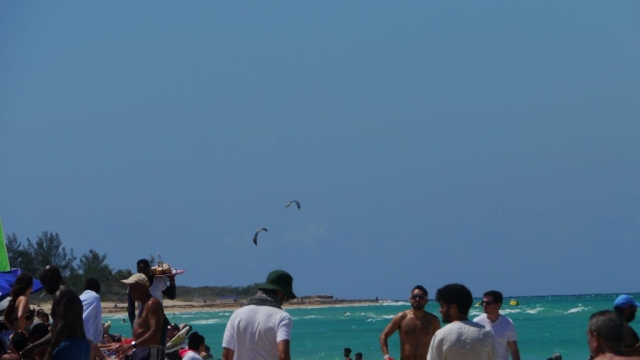 Strandbesucher mit Kitesurfern im Hintergrund – Santa María del Mar, Playas de Este